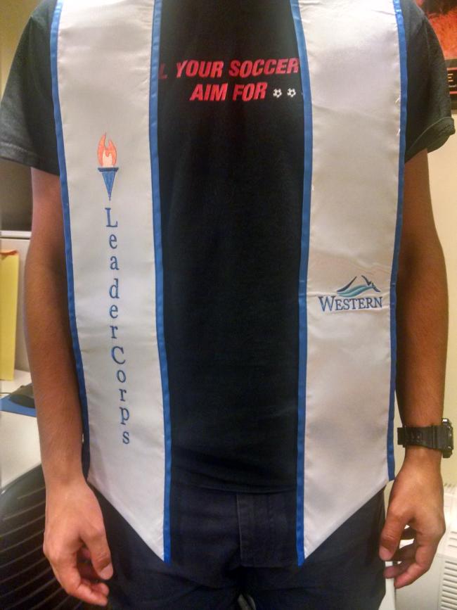 White stole with blue outline that reads Leader Corps on one side and the Western Mountain logo on the other side.